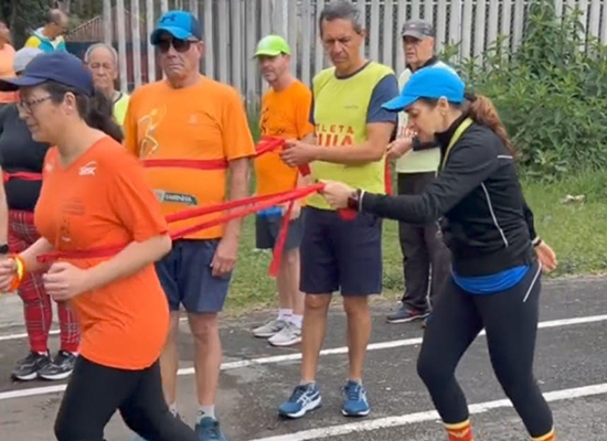 Professora Sheila conduz treinamento com paratletas da Radar DV utilizando faixa de condução em pista ao ar livre.